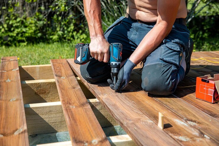 deck-construction-builder-hand-with-electric-screwdriver-installing-impregnated-wooden-boards_664057-1486